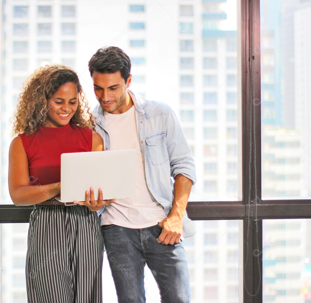 Retrato de jovem casal usando laptop para enviar uma mensagem para contato