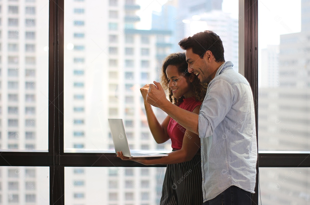 Retrato de jovem casal usando laptop para enviar uma mensagem para contato