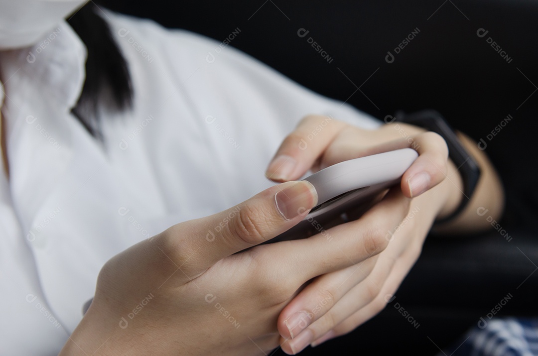 Feche a mão da mulher segurando um telefone celular na cabine do carro.