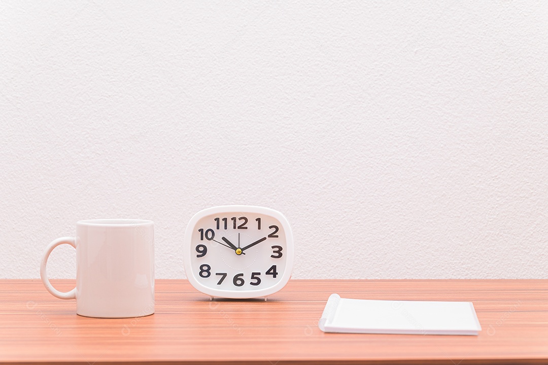 Caderno e o relógio estão sobre a mesa