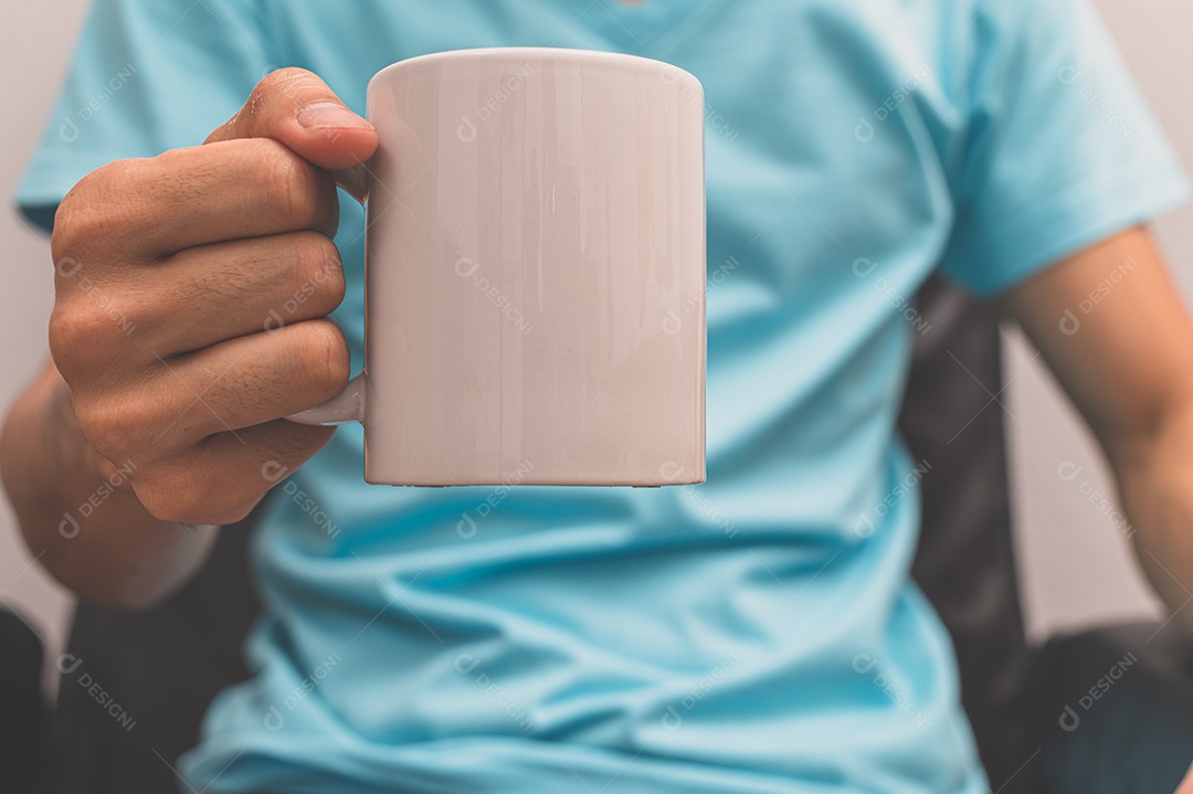 Um homem segurando uma xícara de café