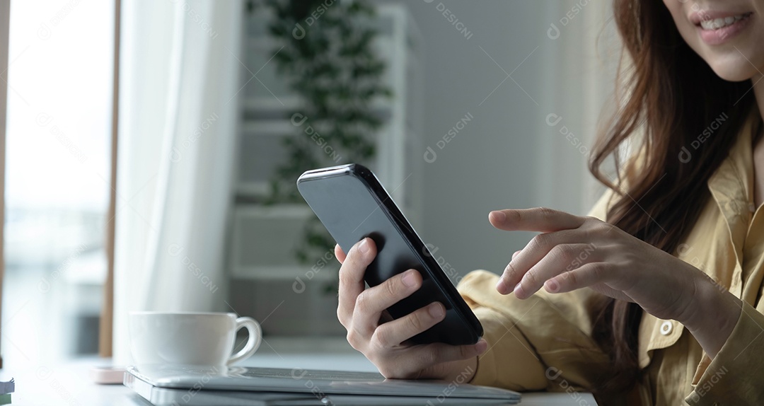 Mão de uma mulher usando smartphone na cafeteria