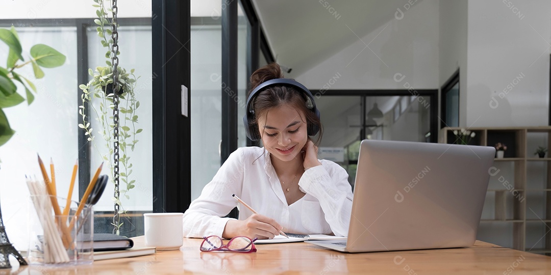 Mulher jovem tendo treinamento online, usando laptop e fone sem fio