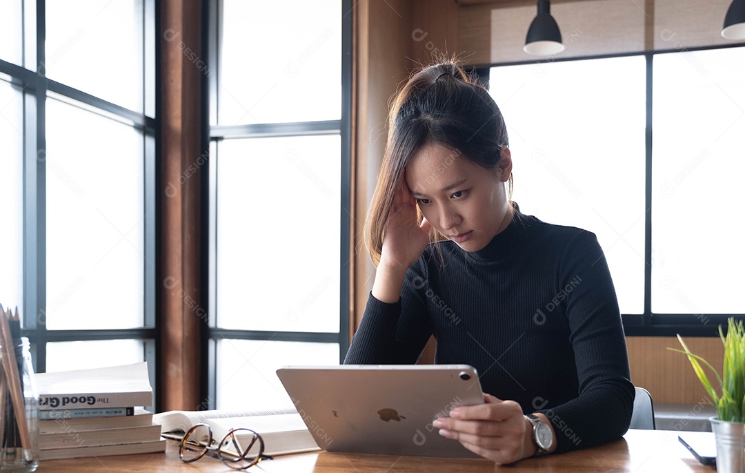 Encantadora mulher asiática trabalhando no escritório usando um laptop