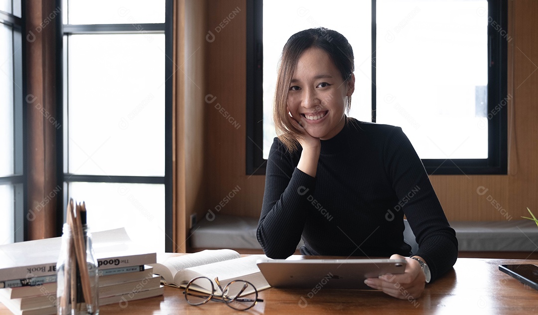 Encantadora mulher asiática trabalhando no escritório usando um laptop