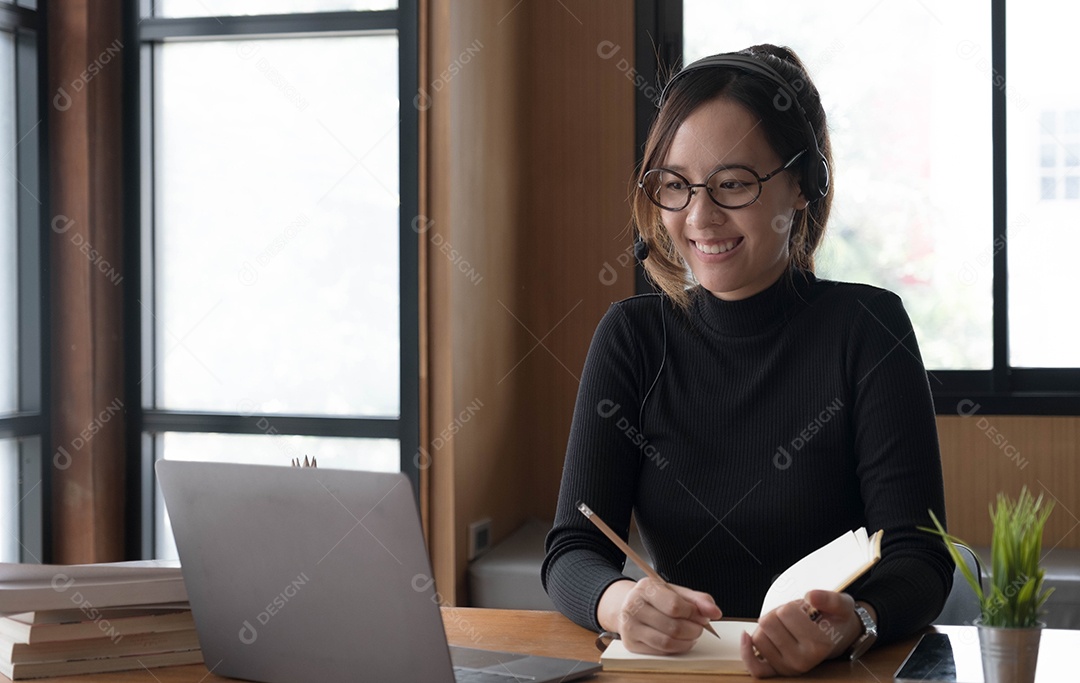 Encantadora mulher asiática trabalhando no escritório usando um laptop