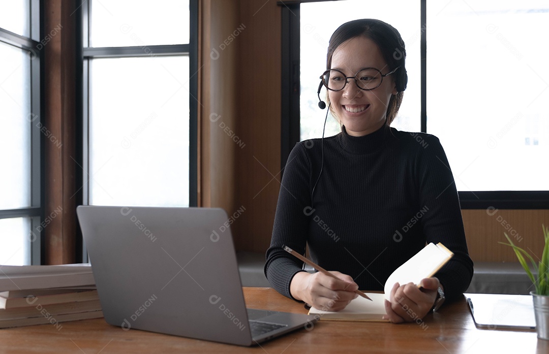 Encantadora mulher asiática trabalhando no escritório usando um laptop