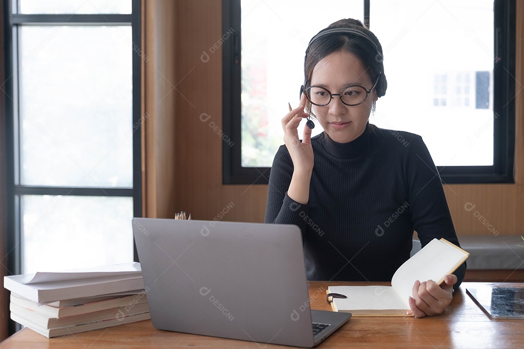 Encantadora mulher asiática trabalhando no escritório usando um laptop