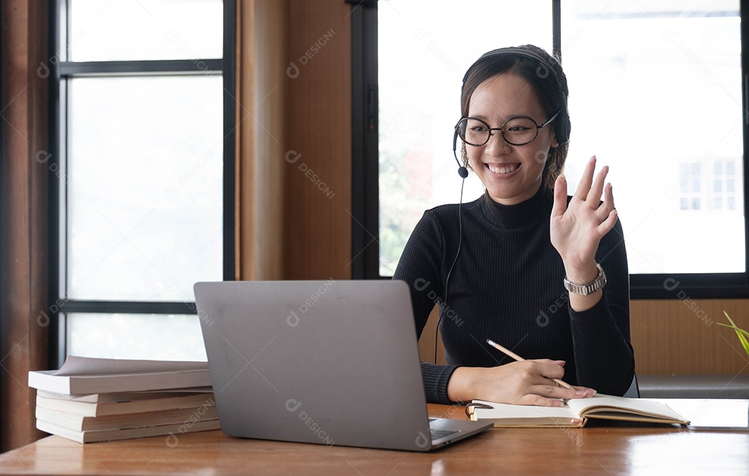 Encantadora mulher asiática trabalhando no escritório usando um laptop