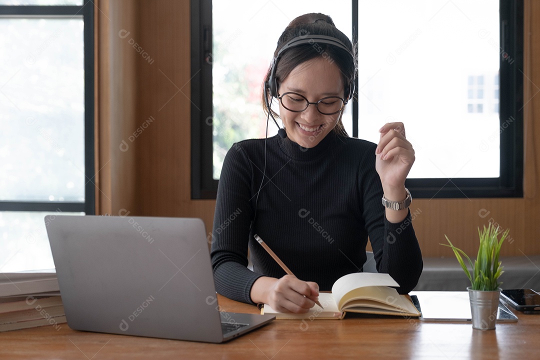 Encantadora mulher asiática trabalhando no escritório usando um laptop