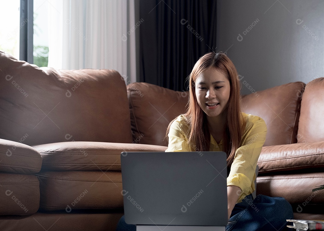 Bela jovem asiática usando laptop na sala