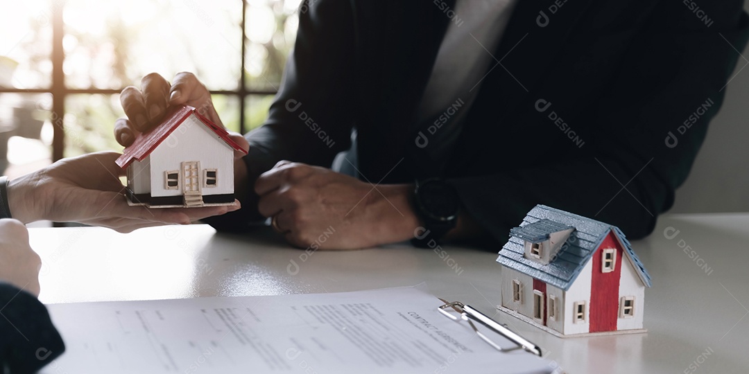 Agente imobiliário dando as chaves para a dona da casa.