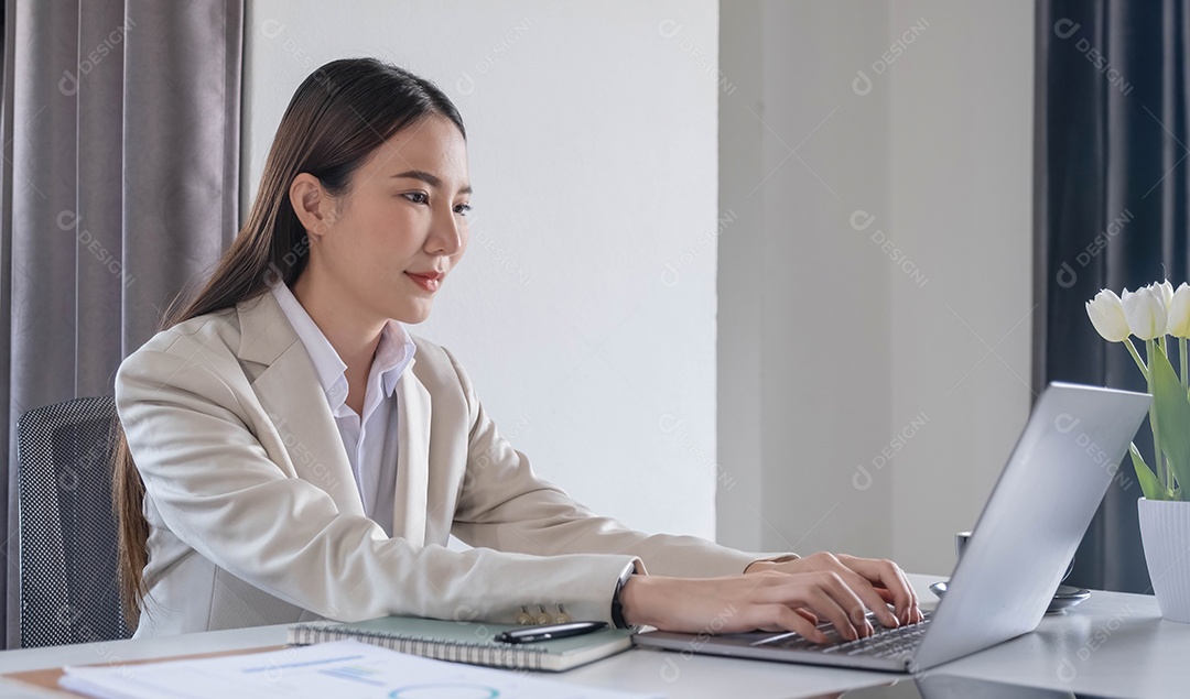 Vista frontal de uma bela empresária asiática trabalhando em uma mesa