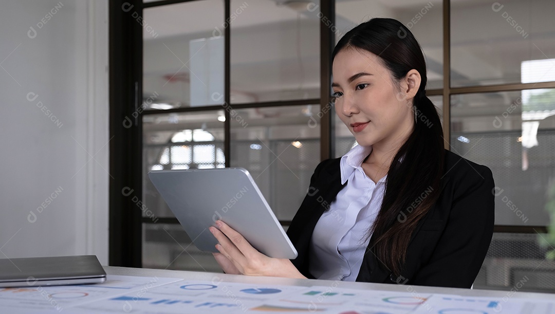 Jovem empresária asiática trabalha em tablet com laptop