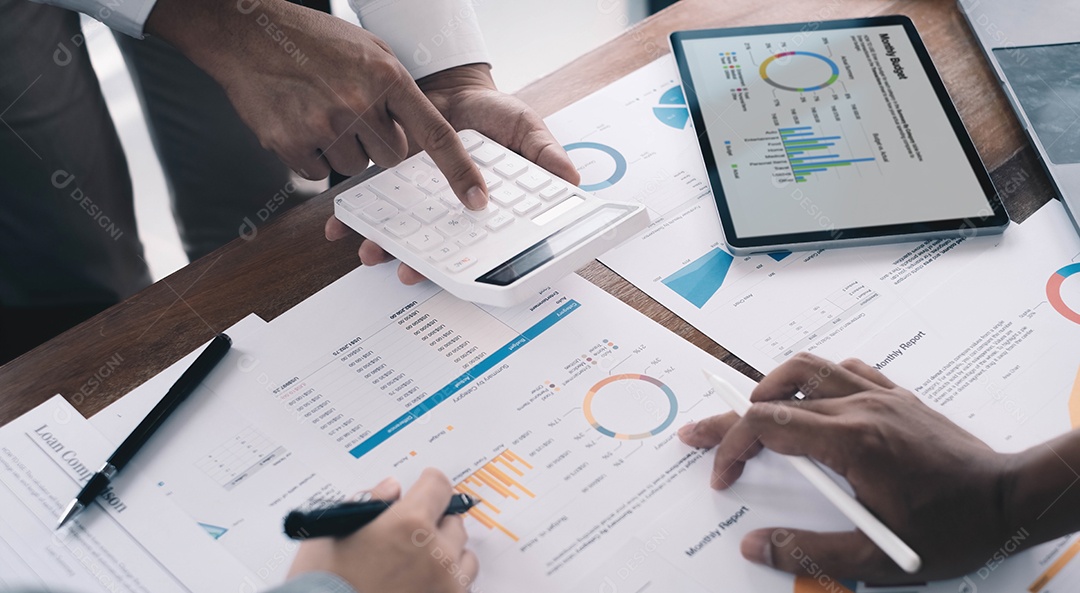 Análise de homem de negócios em papel de dados com mulher de negócios usando calculadora