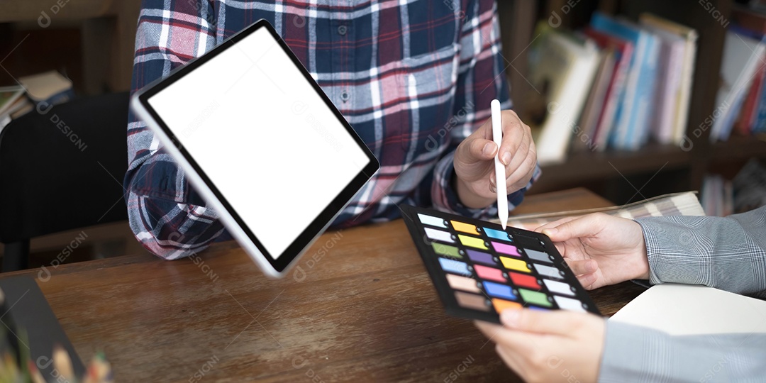 Dois artistas trabalhando em tablet, tom de papel colorido no espaço de trabalho