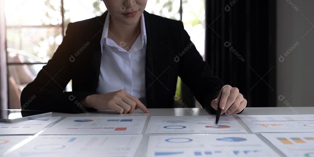 Jovem empresária asiática analisando relatório apontando para gráfico