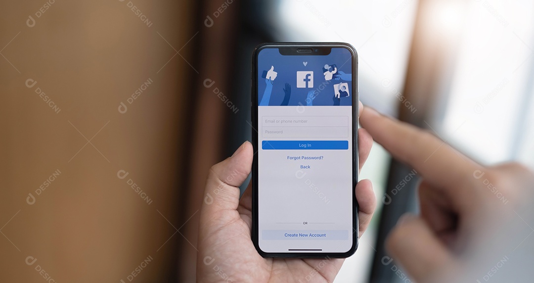 Mulher segurando um iPhone X com serviço social de Internet Facebook na tela.