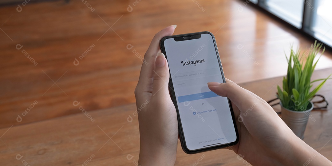 Uma mulher segura o Apple iPhone X com o aplicativo Instagram na tela