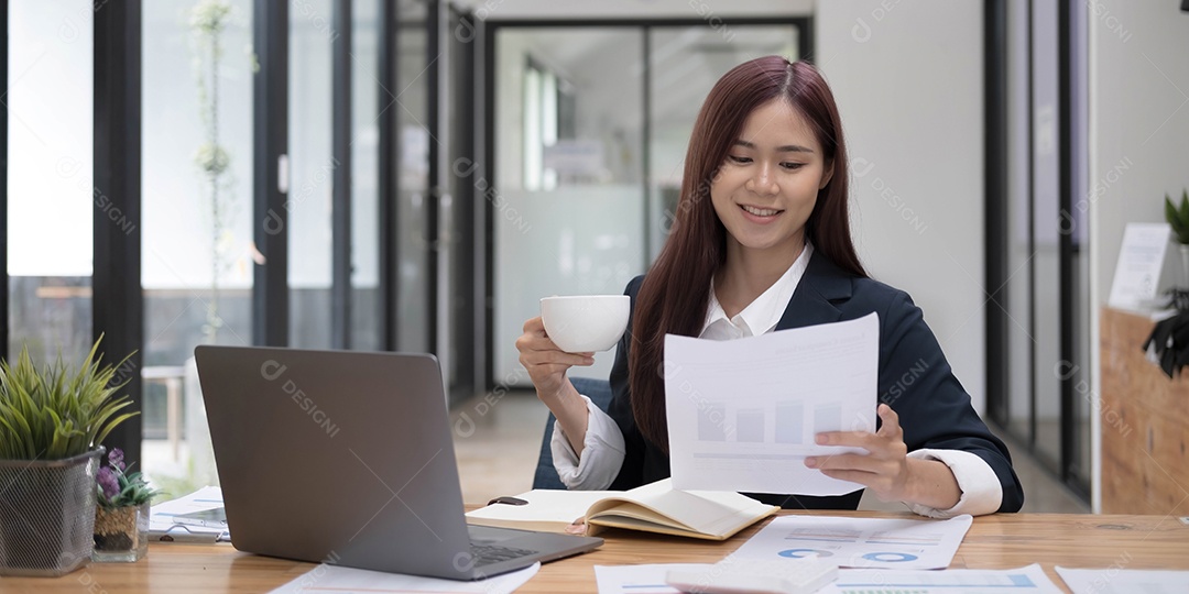 Sorrindo jovem empresária asiática segurando uma caneca de café