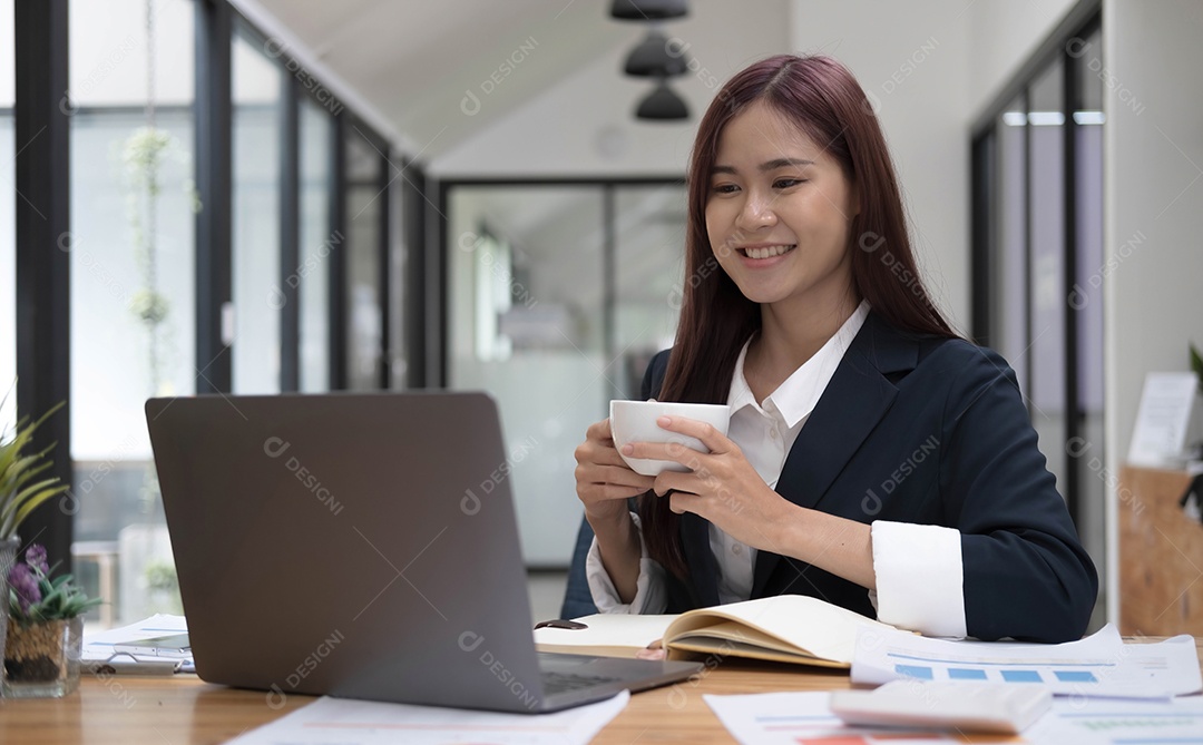 Sorrindo jovem empresária asiática segurando uma caneca de café