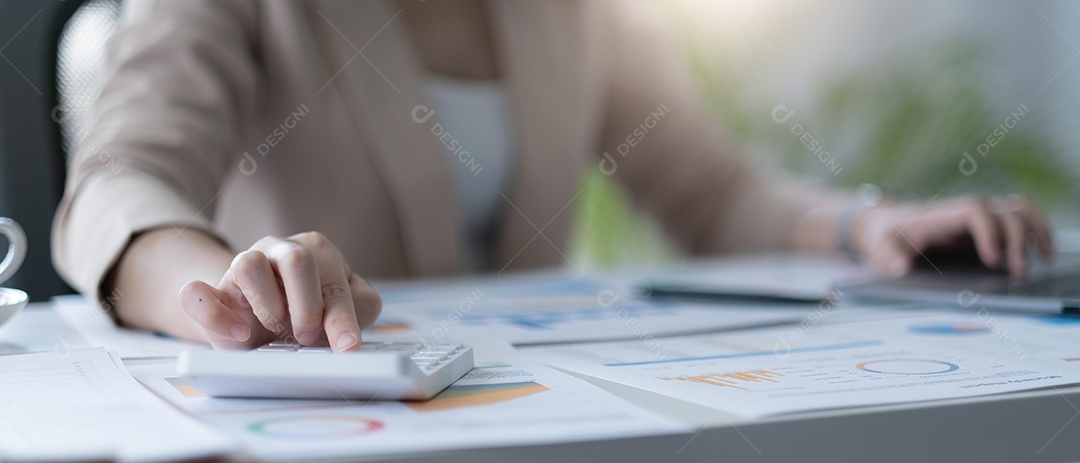 Mulher de negócios usando calculadora e laptop para fazer matemática