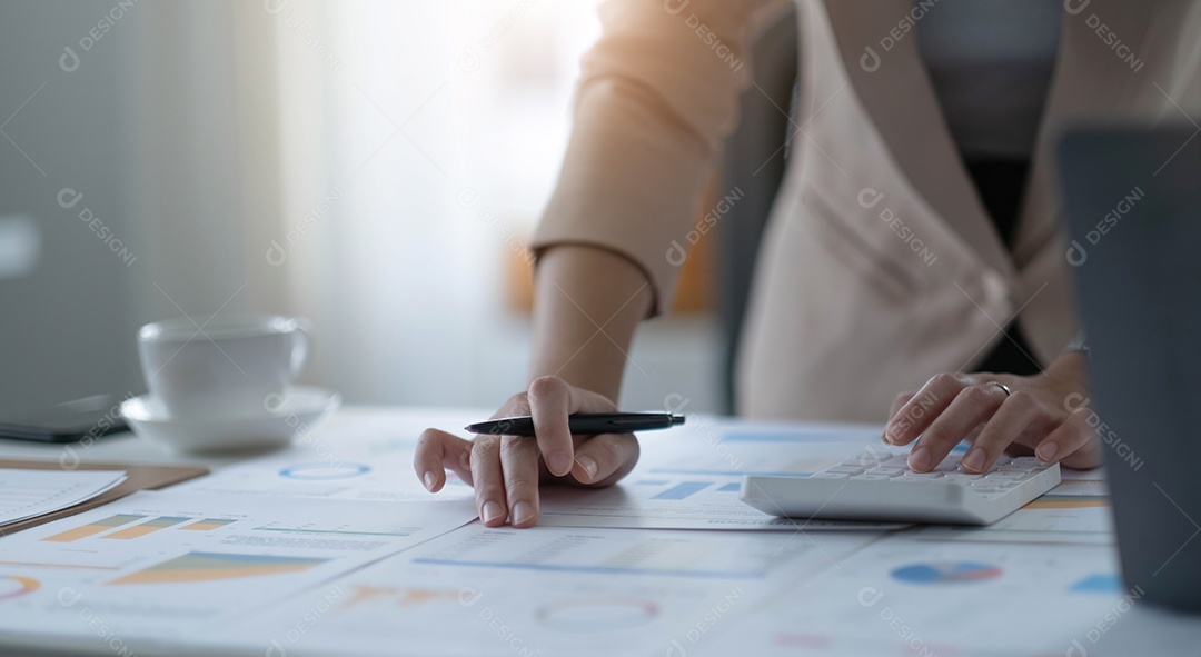 Mulher de negócios usando calculadora e laptop para fazer