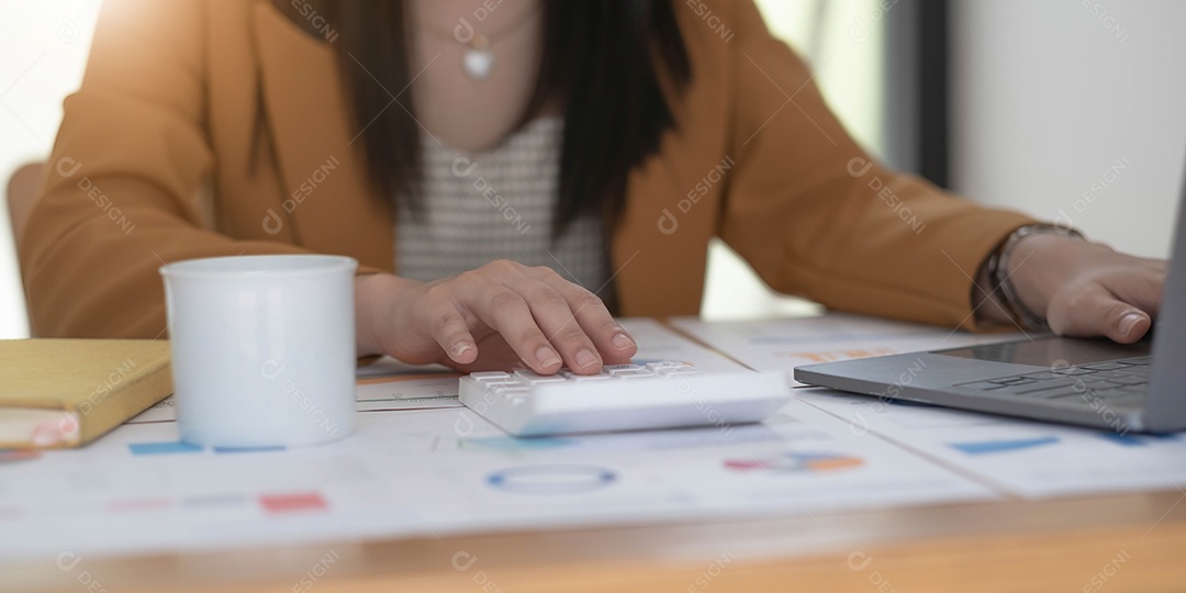 Mãos da mulher de negócios usando uma calculadora