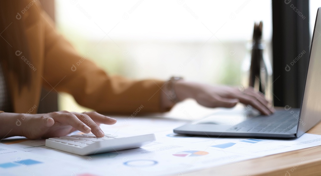 Mão empresária usando calculadora para calcular finanças