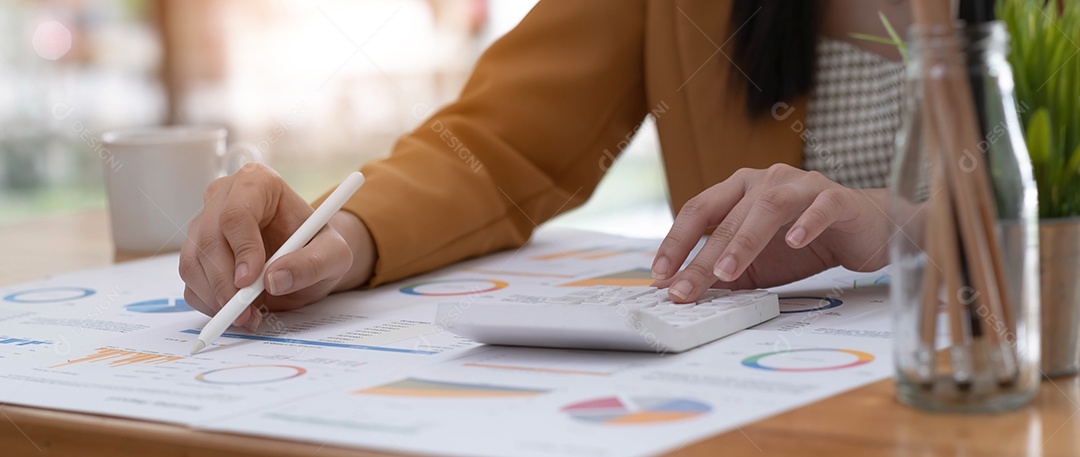 Mulher de negócios usando a calculadora para calcular o relatório financeiro