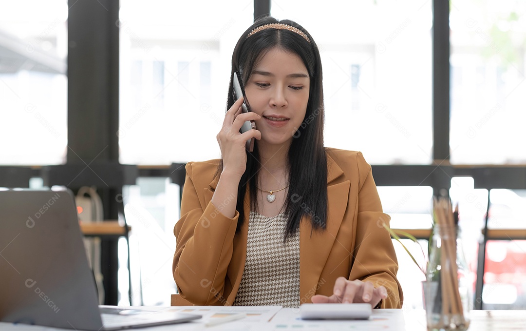 A mulher de negócios asiática tem a alegria de falar ao telefone