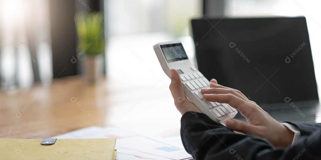 Mãos da mulher de negócios usando uma calculadora