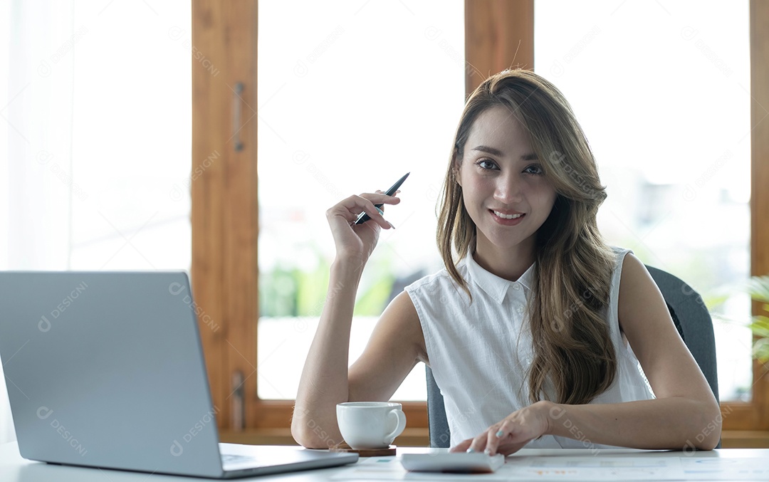 Encantadora empresária asiática trabalhando com um laptop no escritório