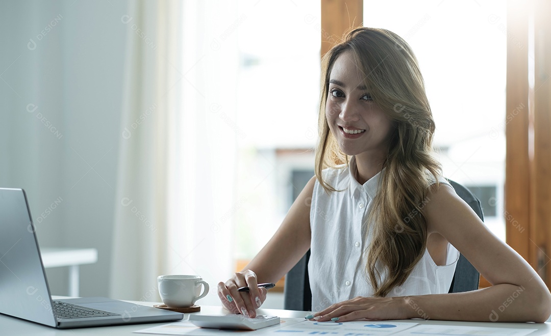 Encantadora mulher asiática trabalhando no escritório usando um laptop