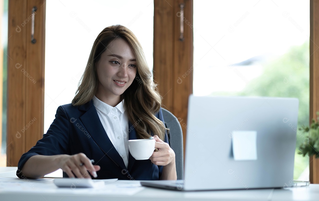 Bela jovem empresária asiática sorrindo segurando uma caneca de café