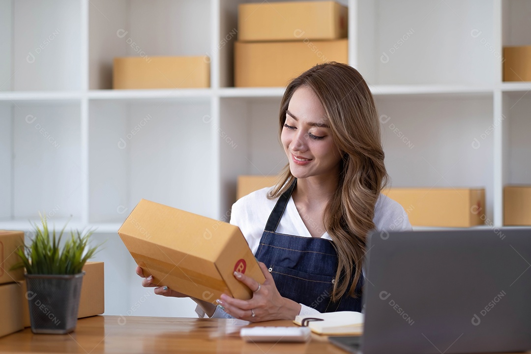 Jovem linda e feliz empresária asiática proprietária da pequena empresa online