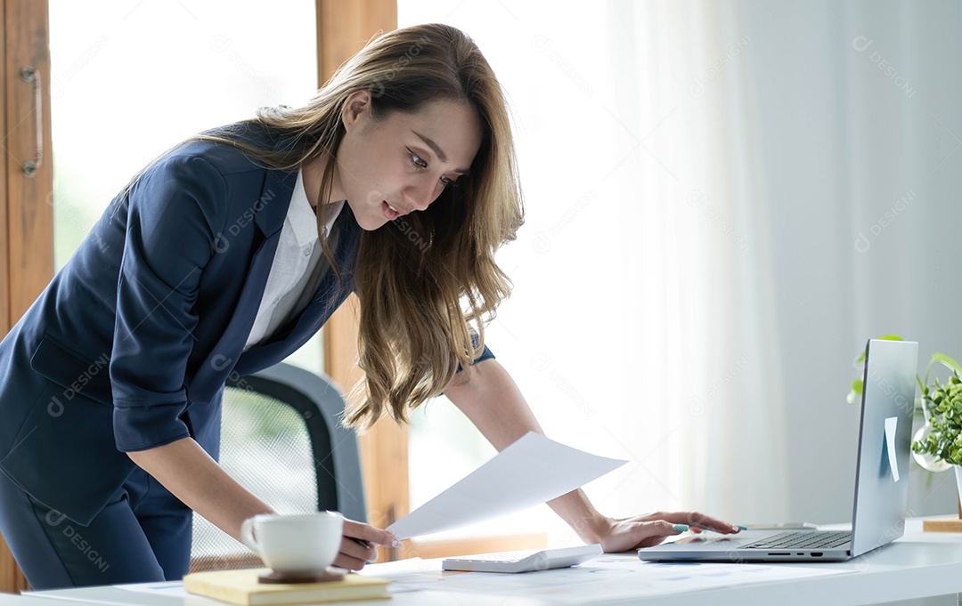 Encantadora mulher asiática trabalhando no escritório usando um laptop