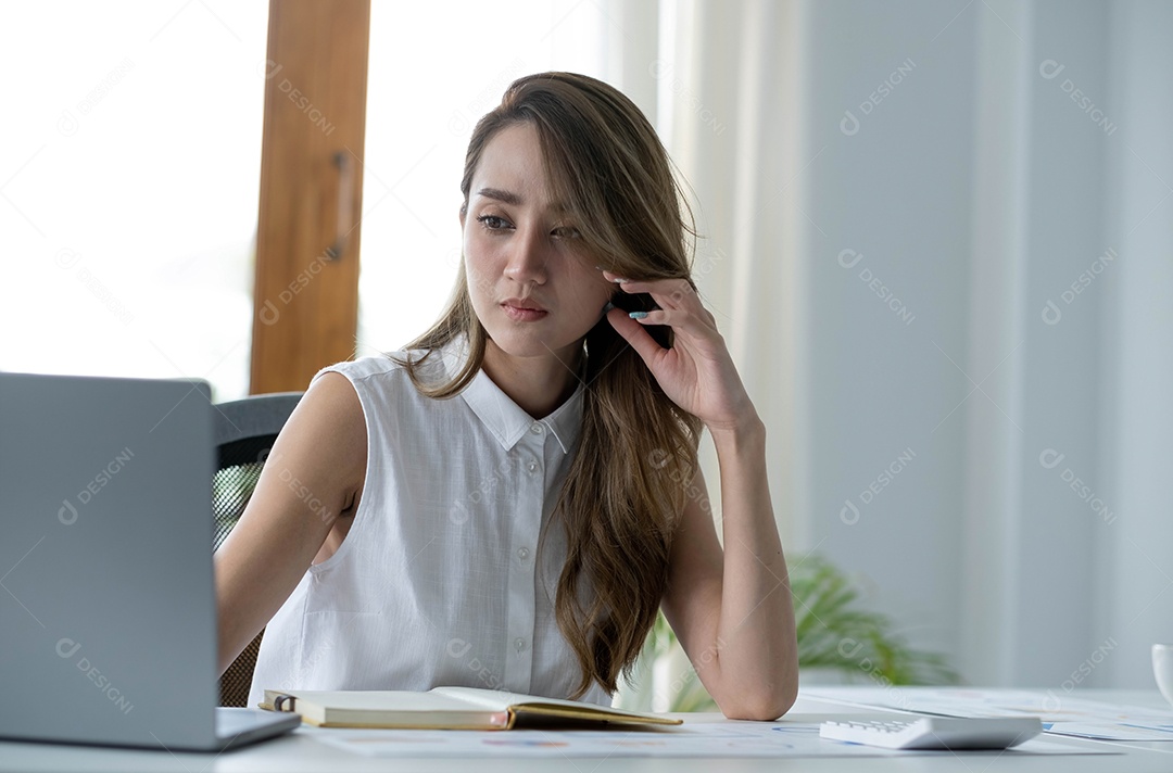Imagem de uma mulher asiática que está cansada e pensando demais no trabalho