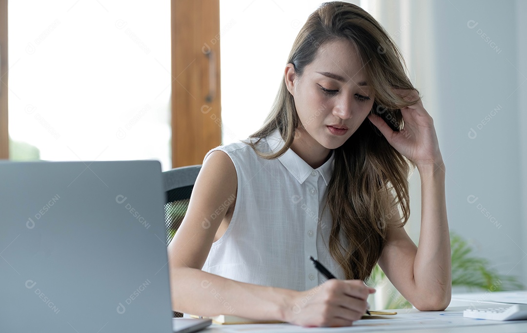 Imagem de uma mulher asiática que está cansada e pensando demais no trabalho