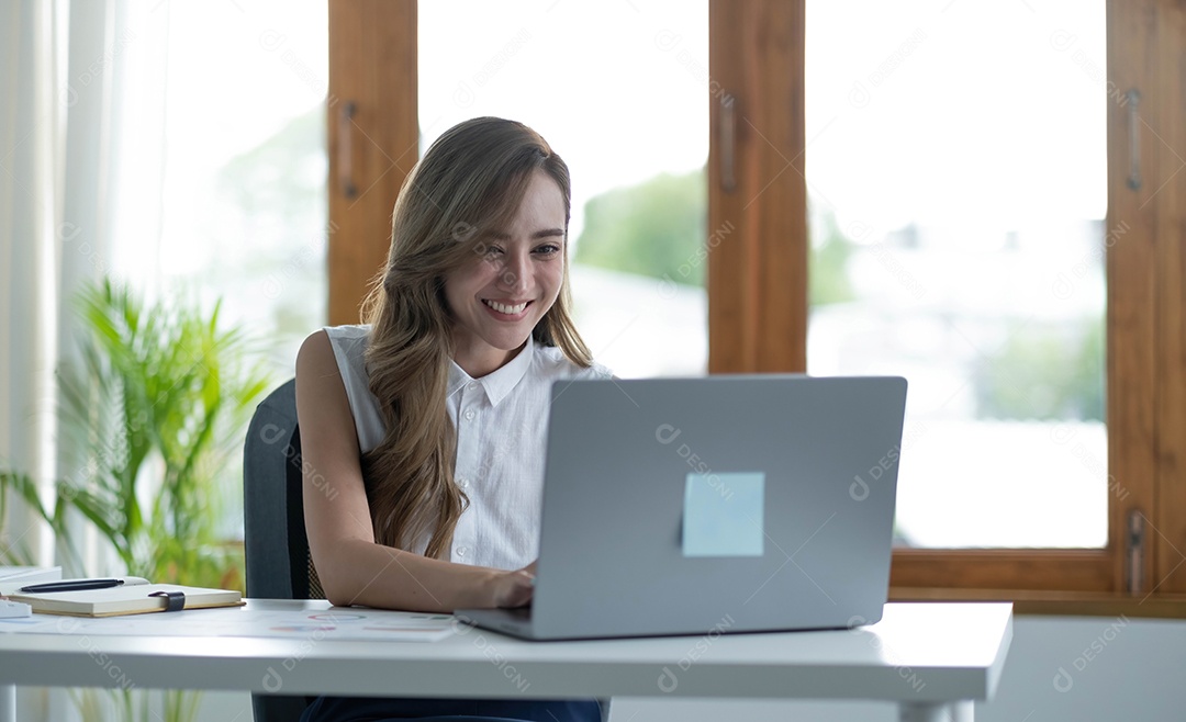 Bela mulher asiática sorridente trabalhando no escritório.