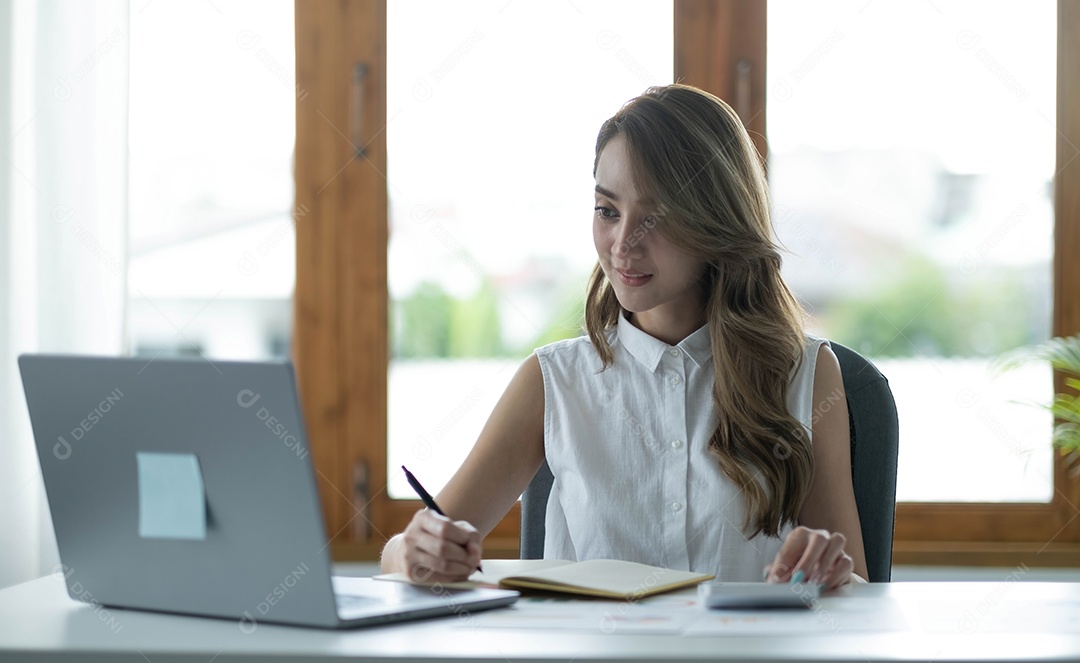 Linda empresária asiática analisa gráficos usando cálculo de laptop