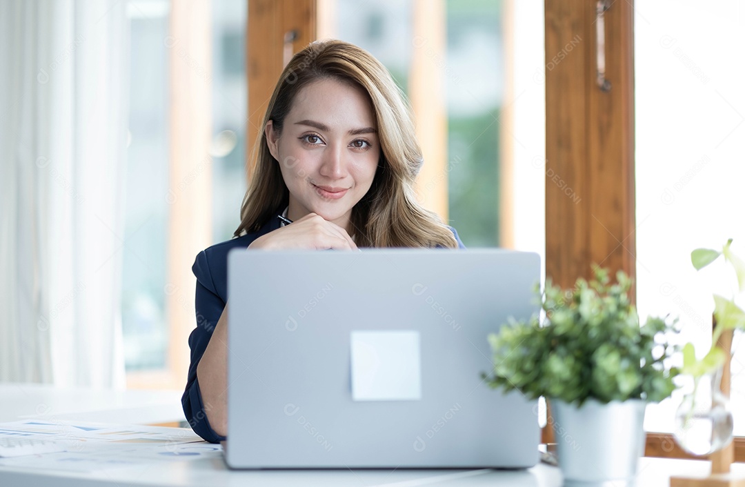 Encantadora empresária asiática trabalhando com um laptop no escritório