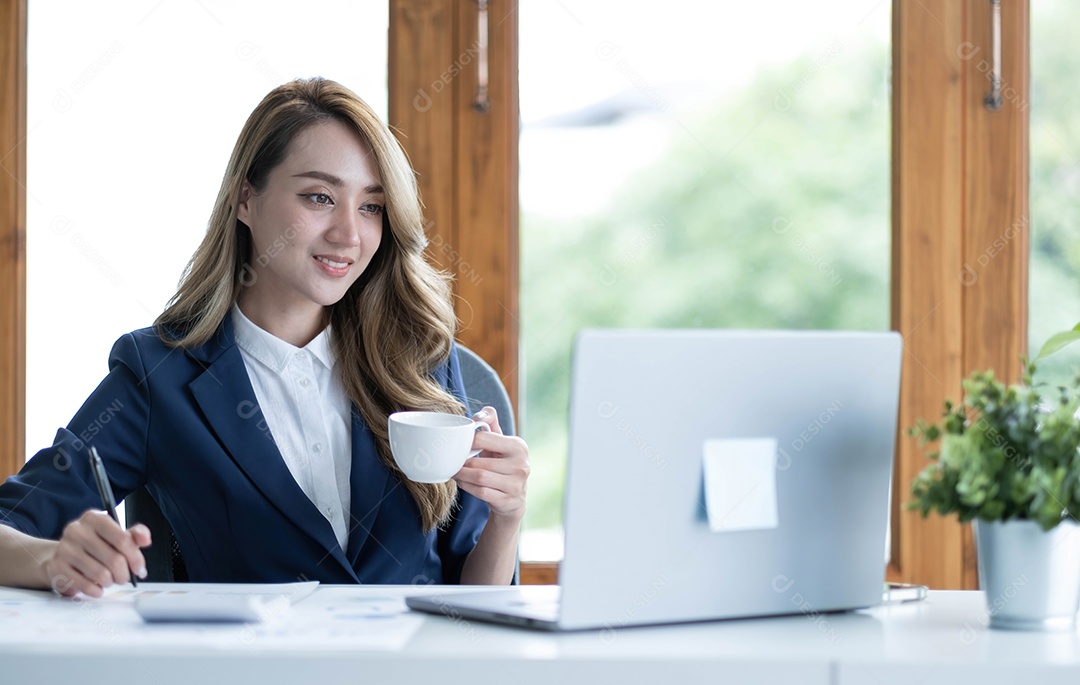 Bela jovem empresária asiática bebendo um café trabalhando