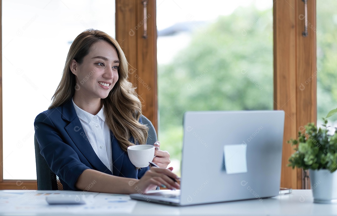 Bela jovem empresária asiática bebendo um café trabalhando