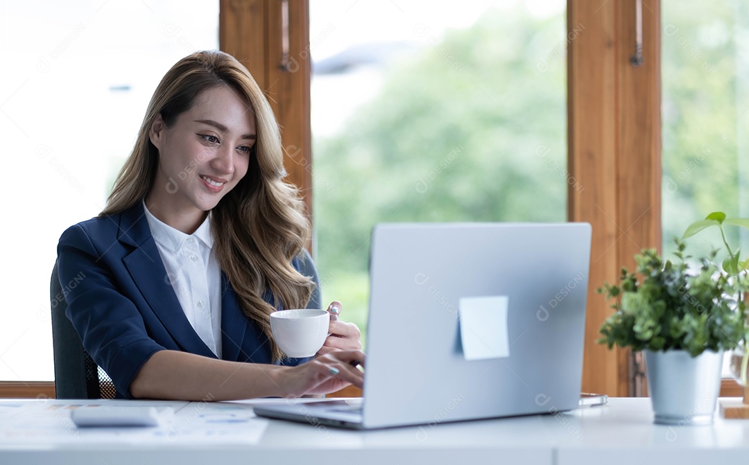 Bela jovem empresária asiática bebendo um café trabalhando