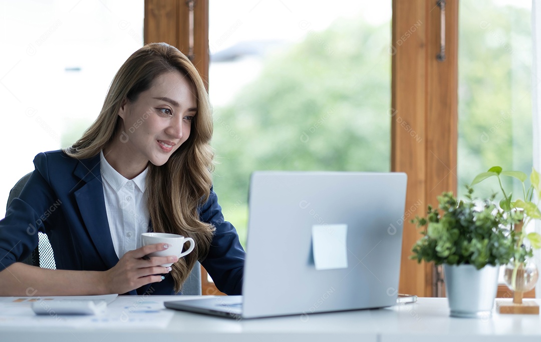 Bela jovem empresária asiática bebendo um café trabalhando