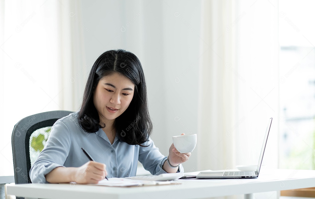 Mulher asiática sentada no seu local de trabalho