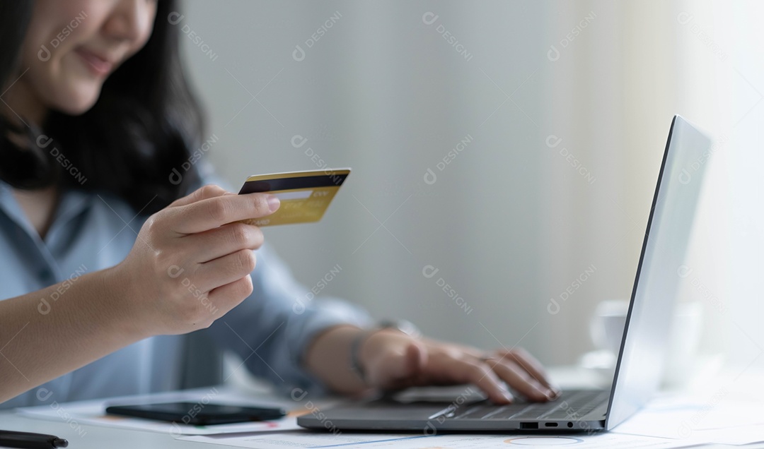 Mulher asiática fazendo compras online segurando cartão de crédito