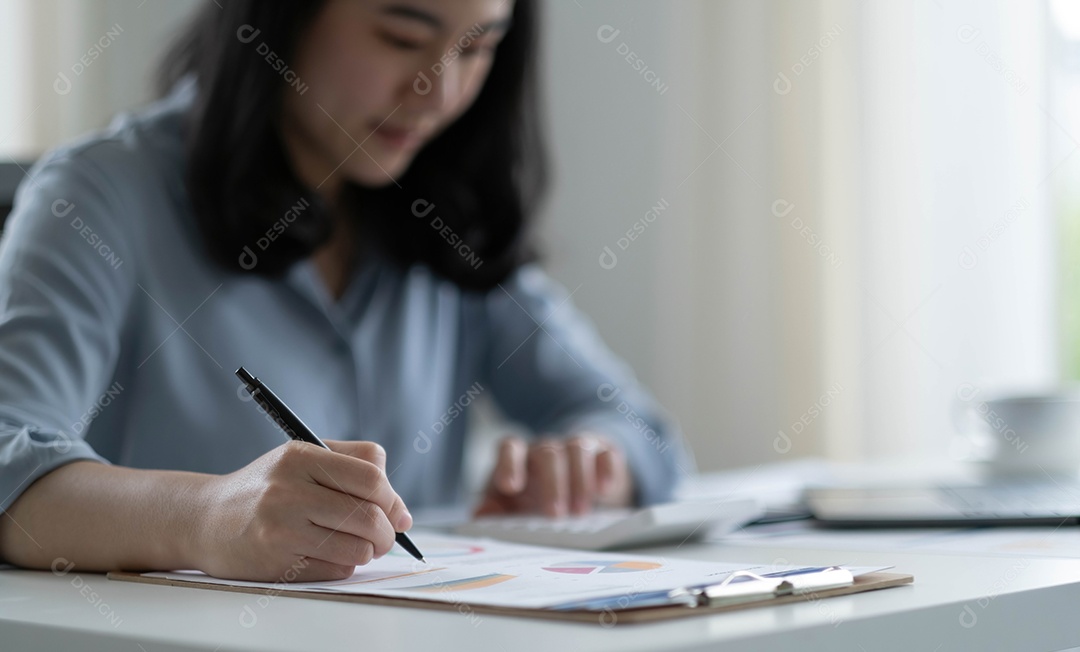 Mulher asiática sentada no seu local de trabalho