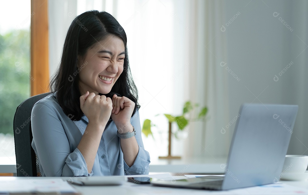 Mulher asiática sentada comemorando no trabalho